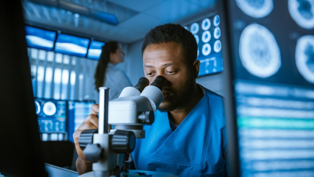 Cancer researcher looking at epigenetic biomarkers under microscope